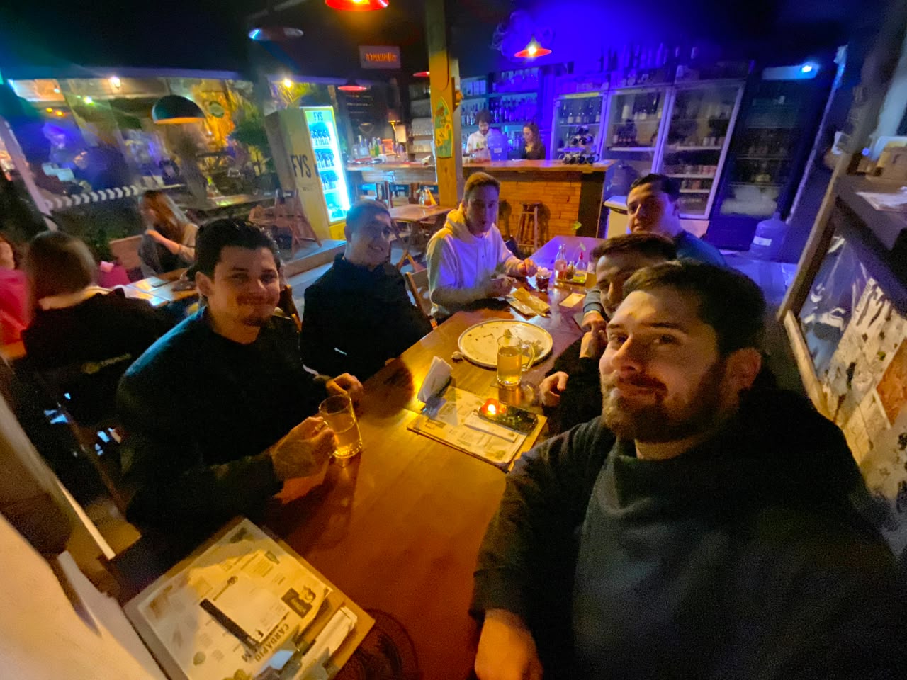 A turma conversando em uma mesa de bar