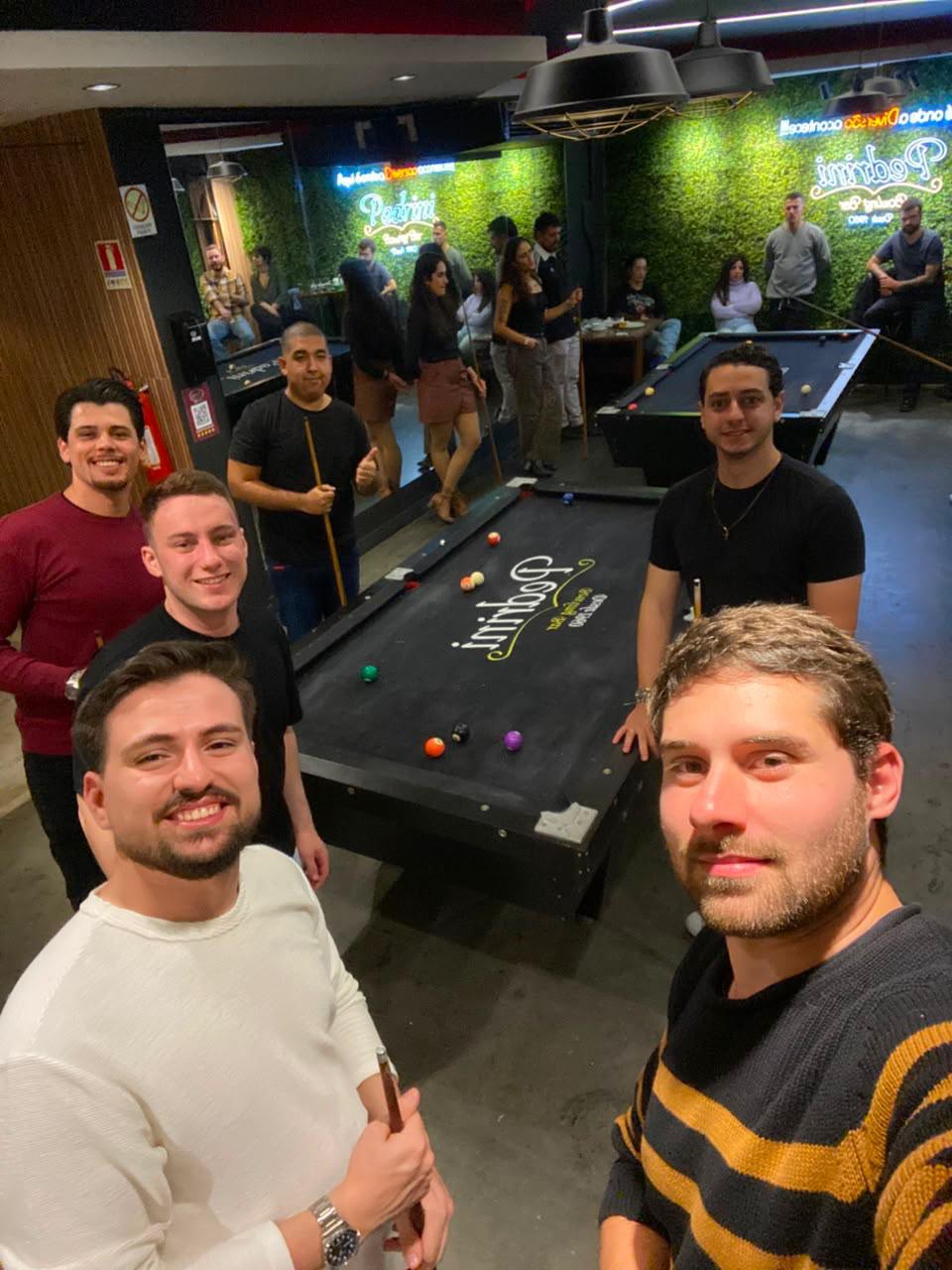 Amigos posando para uma selfie na mesa de sinuca